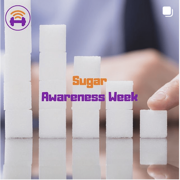 Sugar Cubes stacked in descending Columns from left to right. in the background, there is the hand of a person, and the writing in the foreground reads "Sugar Awareness Week" | Fit4Mii app