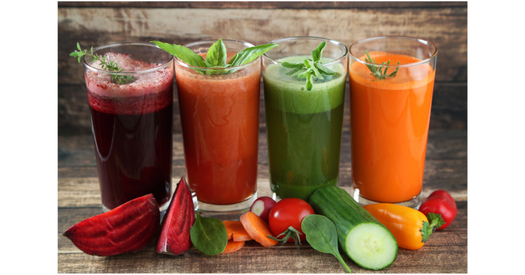 4 glasses of fruit and vegan shakes smoothies, with beetroot, carrots, cucumbers and paprika